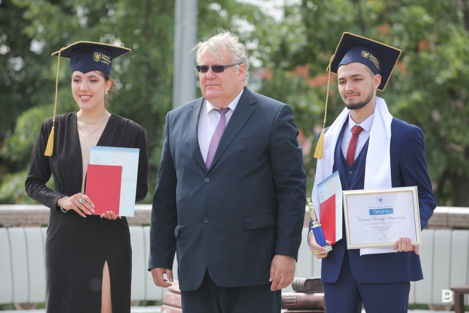 и. о. ректора КФУ Дмитрий Таюрский вручает красный диплом выпускникам