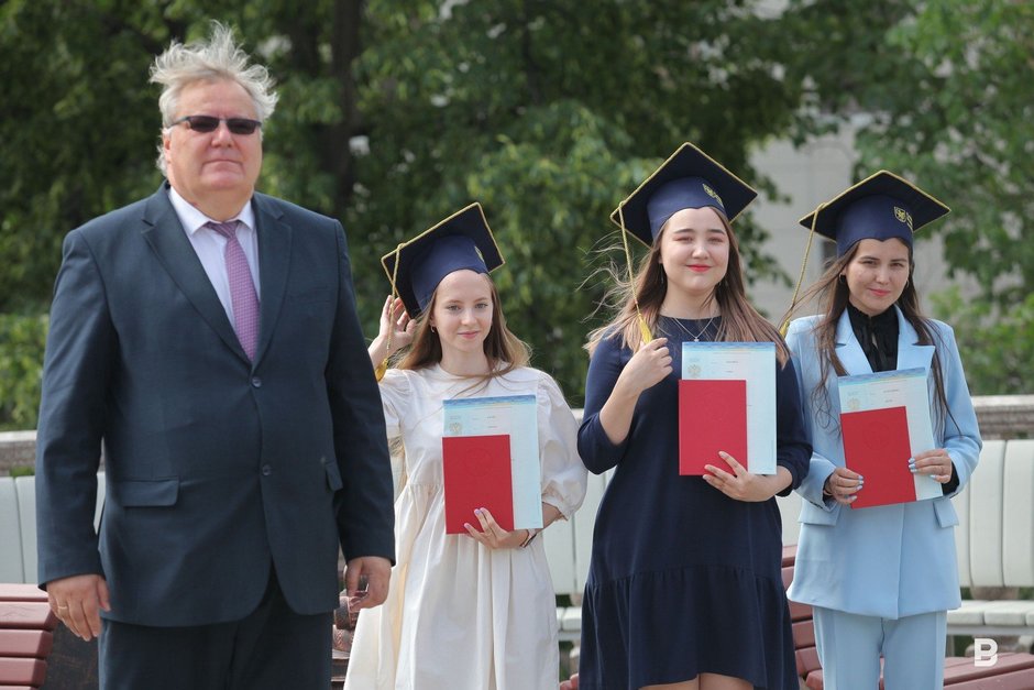 и. о. ректора КФУ Дмитрий Таюрский вручает красный диплом выпускницам
