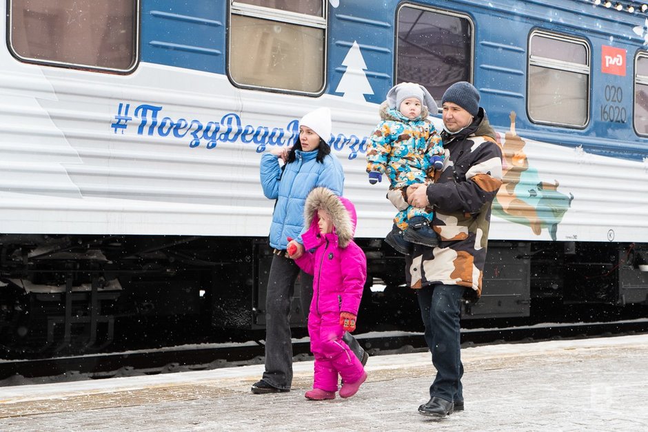 Семья около поезда деда мороза