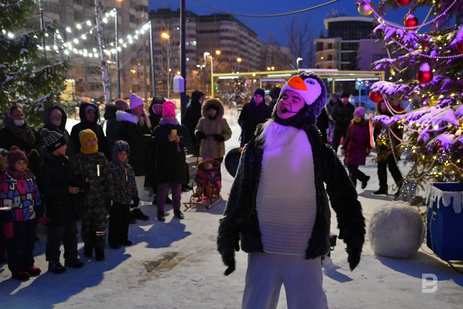 Аниматор в костюме пингвина и люди